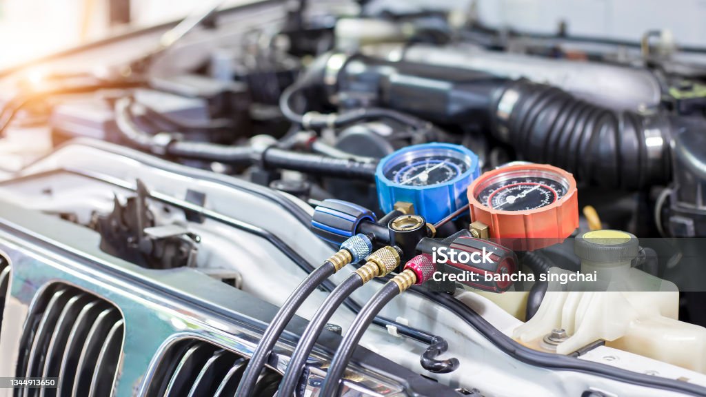 Car air conditioner check service, leak detection, fill refrigerant.Device and meter liquid cooling in the car by specialist technicians. Air Conditioner Stock Photo