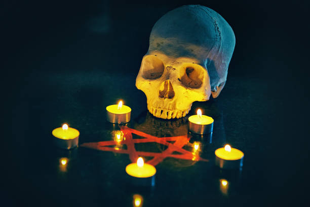altar satânico: velas nos ápices de um pentagrama vermelho de sangue, com crânio humano - inferno fire flame skull - fotografias e filmes do acervo