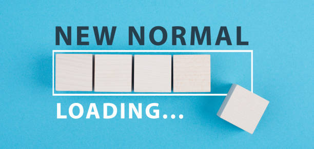 The words new normal are standing on wooden cubes, loading bar, blue colored background stock photo