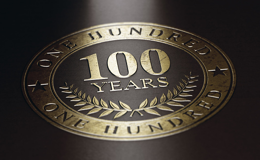 Golden marking over black background with the text 10O years. Concept for a 100th anniversary celebration announcement. 3D illustration.