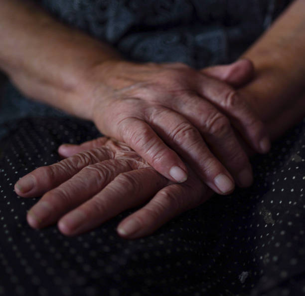 istock Great-grandmother  sitting on a couch with crossed hands 1344918258
