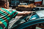 Mature Man washing car windshield