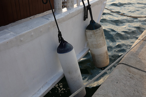 Mooring fender hangs on a boat, close-up.