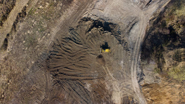 istock Bulldozer and trucks on a disposal site - aerial view 1344918592