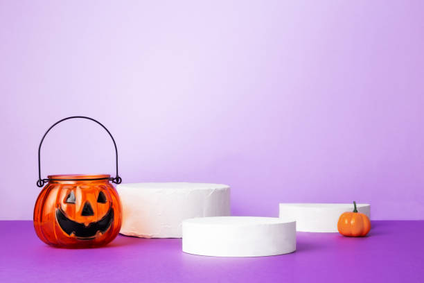 istock Halloween celebration. Various decarative pumpkins on white round podiums on purple background 1344919563
