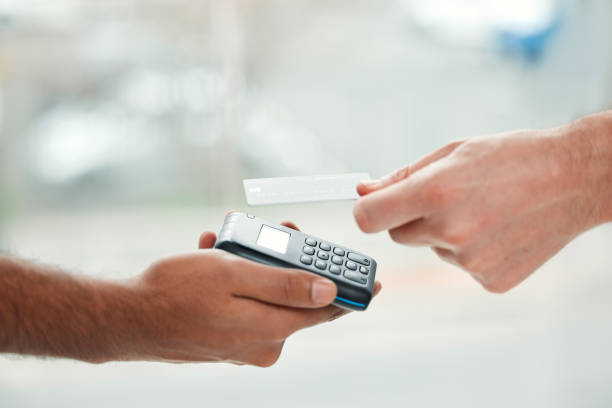 istock Closeup shot of an unrecognizable man paying his bills via wireless card reader 1344920418