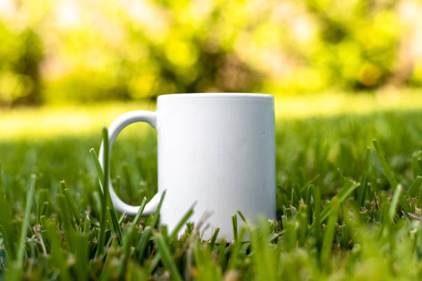 istock White porcelain mug cup isolated on green grass background with copy space. 1344921599