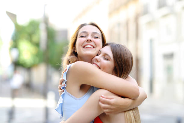 istock Happy friends cuddling affectionate in the street 1344922012