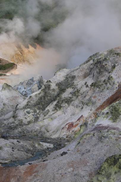 Stream flows through a volcano crater Steam rising from a sulphurous stream flowing through a volcano crater sulphur landscape fumarole heat stock pictures, royalty-free photos & images