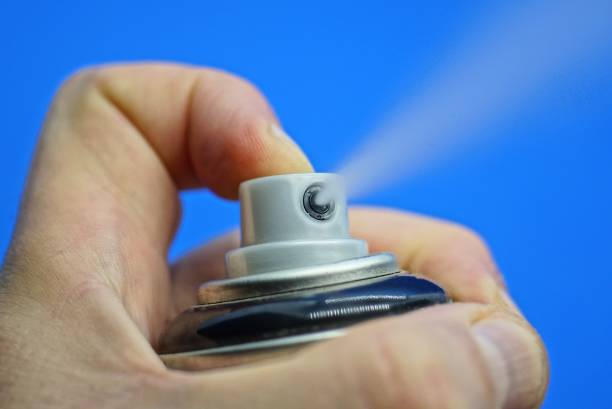 istock hand holds a black deodorant and a finger presses the gray button with a white spray 1344924794