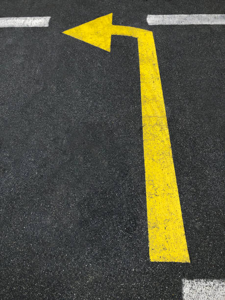 istock Left turn sign made in yellow on black asphalt 1344926973