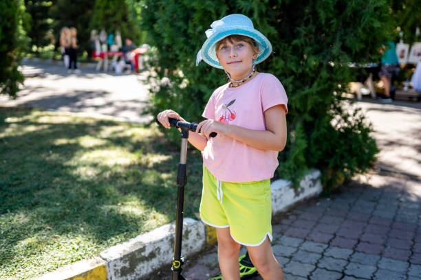 Little girl using scooter and smiling