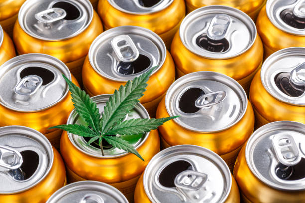 golden beer cans.the sale of products and drinks with addition of hemp (cannabis) beer cans with weed on one of them - food and drink industry imagens e fotografias de stock