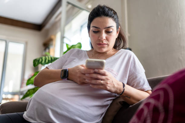 istock pregnant woman using her smartphone at home 1344928370