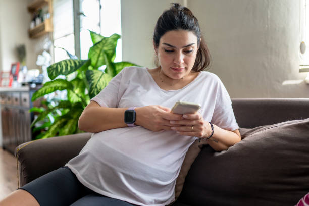 istock pregnant woman using her smartphone at home 1344928410