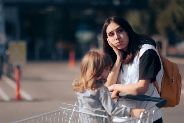 피곤한 엄마 쇼핑 와 그녀의 딸 밀어 a 슈퍼마켓 카트 - poverty 뉴스 사진 이미지