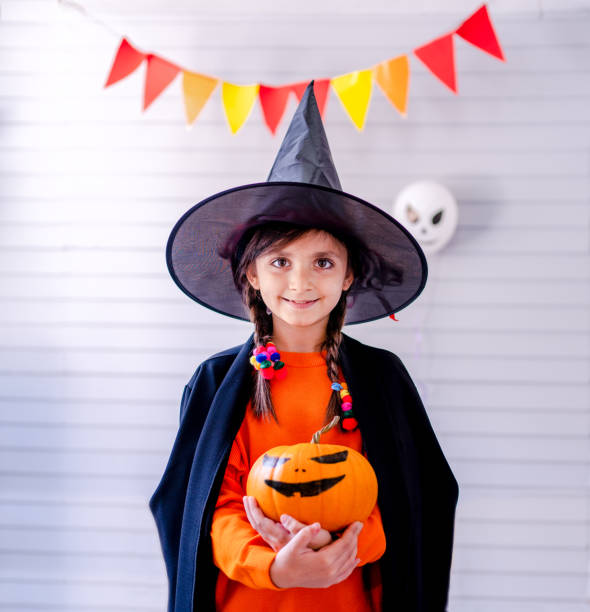 istock girl with pumpkin  in halloween 1344930400