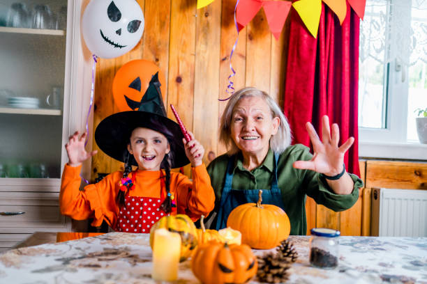 Grandmother and child celebrating Halloween at home. stock photo