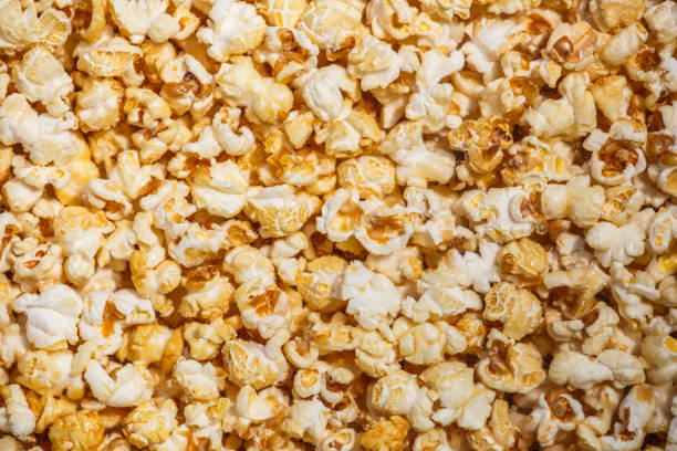 istock Heap of delicious popcorn, isolated on white background. Scattered popcorn texture background. Top view.popcorn with caramel 1344933205