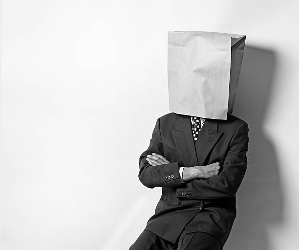 Buisness man with paper bag on head Businessman wearing a paper bag on his head in black and white anonymous businessman with paper bag on his head stock pictures, royalty-free photos & images