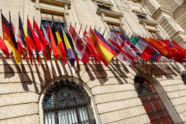 Row of many different flags on the wall Row of many different flags on the wall . Country patriotic symbols . International flags on Hofburg palace in Vienna Austria coalition building stock pictures, royalty-free photos & images