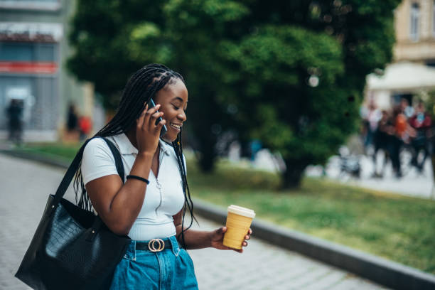 istock African american woman using smartphone and drinking coffee takeaway 1344937080