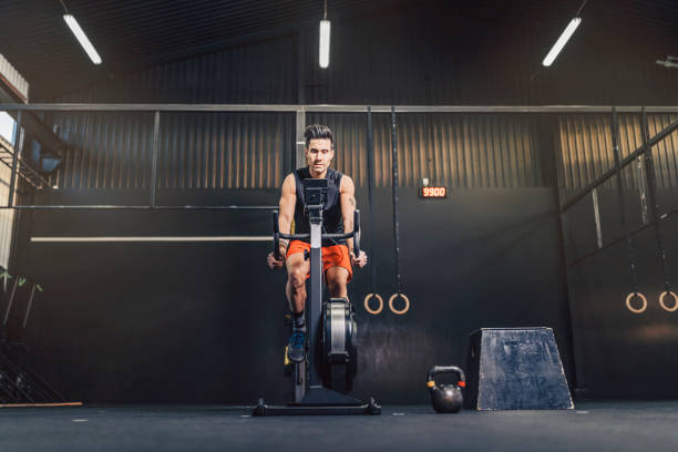 Male athlete cycling in gym