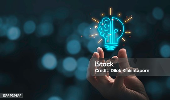 istock Hand holding drawing virtual lightbulb with brain on bokeh background for creative and smart thinking idea concep 1344939844
