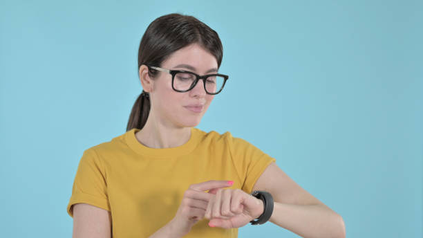 istock Young Woman Using Apple Watch  on Purple Background 1344942615