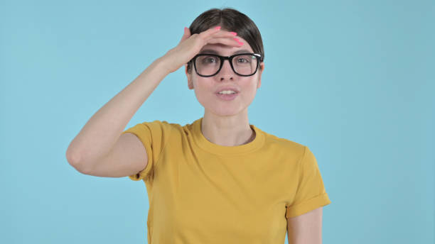 istock Inquisitive Young Woman Searching for Something on Purple Background 1344943964