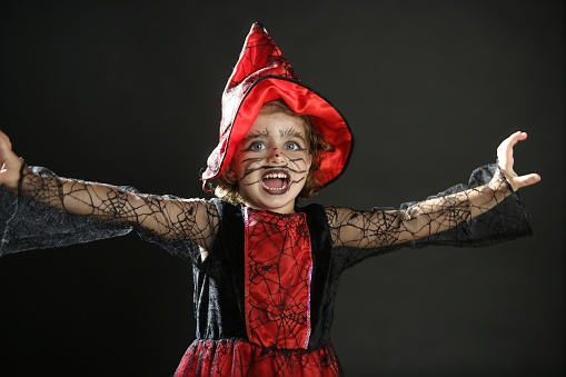 close-up of a white-haired witch with her broom against an abstract background