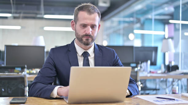 istock Ambitious Businessman working on Laptop on Office Desk 1344944952