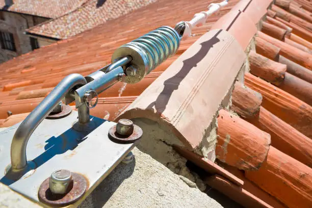 Horizontal lifeline fall protection system with inox stainless cable on terracotta roof used to prevent the danger of falling "n