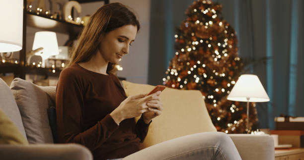 istock Woman chatting with her smartphone at Christmas 1344945771