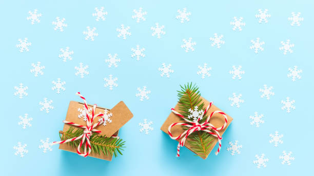 istock Holiday gift boxes with fir-tree and snowflakes on blue background 1344946956