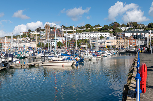 Torquay, UK. Wednesday 29 September 2021. Boats in Torquay Harbour with town and shops behind.