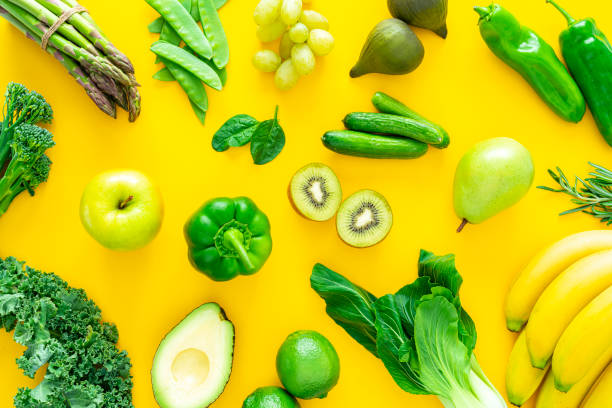 istock Green fruits and vegetables on yellow background 1344947321