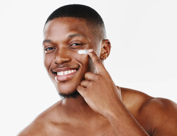 istock Studio portrait of a handsome young man applying moisturiser against a white background 1344947372