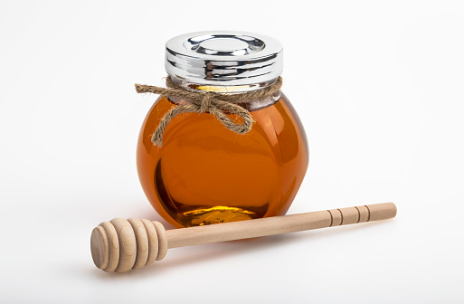 Wooden dipper and honey jar on white background , Organic natural ingredient