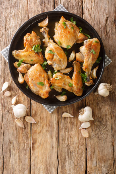 istock Pollo Al Ajillo Classic Spanish Fried Garlic Chicken close-up on a plate. Vertical top view 1344954795