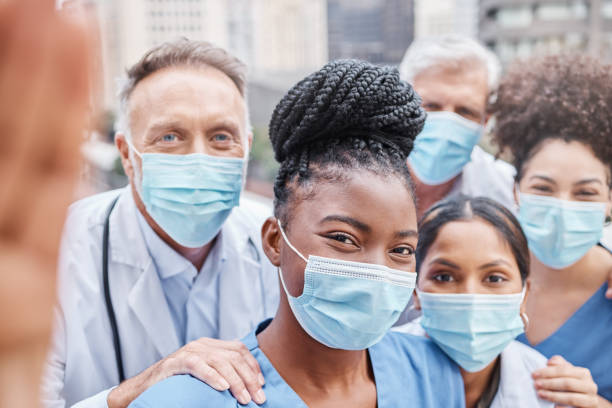 photo d’un groupe de médecins prenant un selfie dans la ville - healthcare and medicine smiling group of people lab coat photos et images de collection