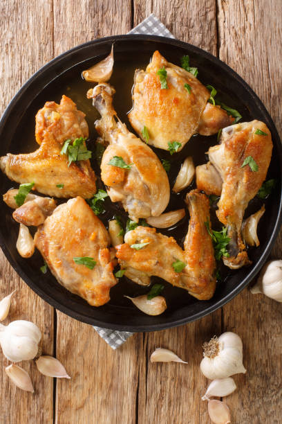 istock Spanish Garlic Chicken Pollo Al Ajillo close-up on a plate. Vertical top view 1344955816