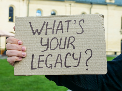 Hand holding a poster What is your legacy.