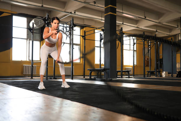 istock Fit woman using battle ropes during strength training at the gym. 1344958528