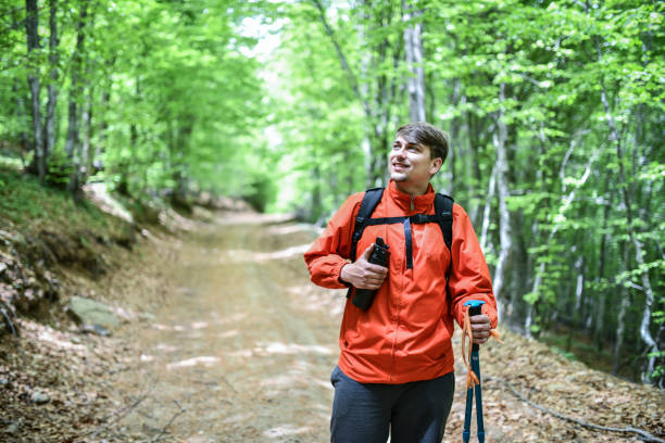 istock Young Male With Water Bottle Enjoying Walk Through Green Forest 1344958602