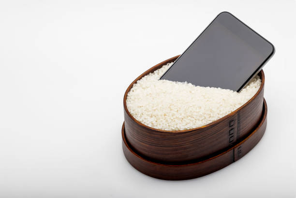 A wet smartphone is dried in japanese rice on wooden box with copy space , Can be used as a background A wet smartphone is dried in japanese rice on wooden box with copy space , Can be used as a background empty bento box stock pictures, royalty-free photos & images