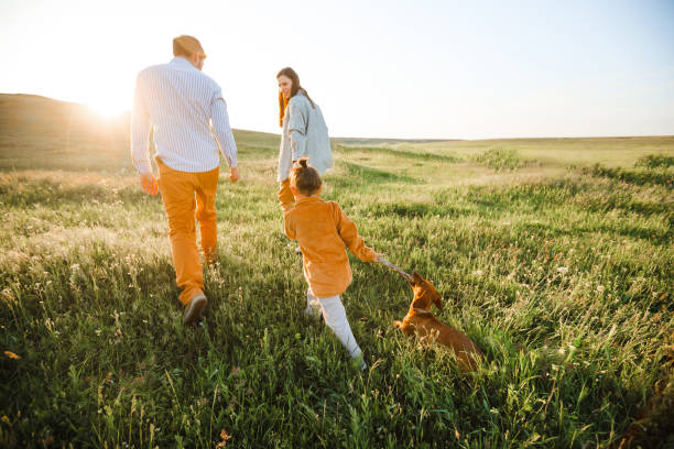 istock A hipster family walks in a summer field. 1344958622