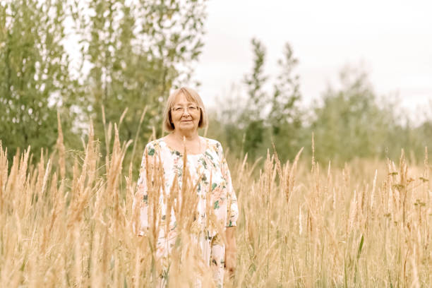 istock An elderly woman in the tall grass with spikelets. Autumn 1344960814