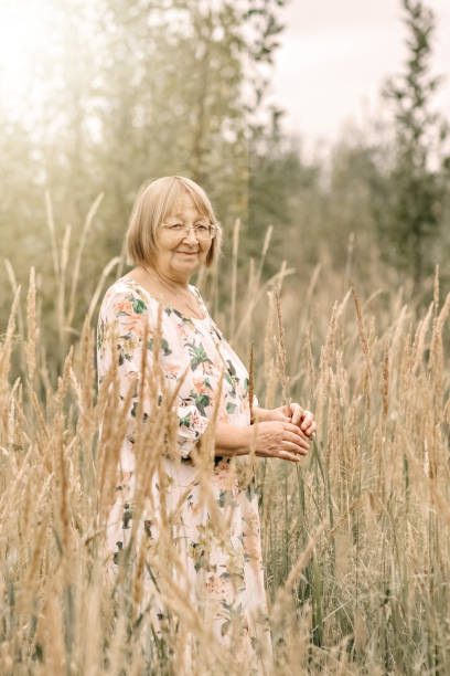 istock An elderly woman in the tall grass with spikelets. Autumn 1344961368