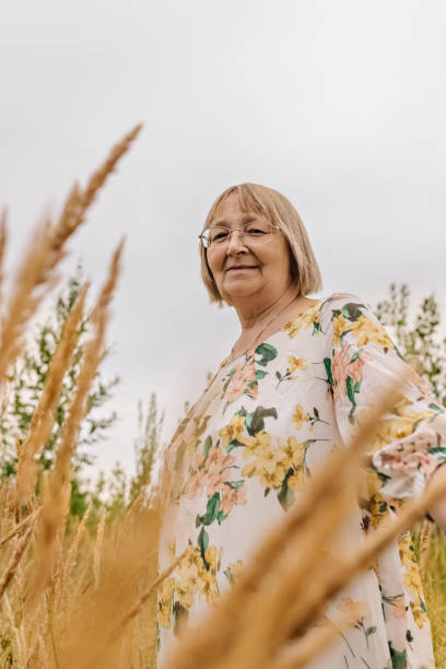 istock An elderly woman in the tall grass with spikelets. Autumn 1344961445